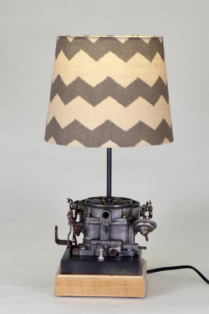 carburetor from automobile mounted on wood base